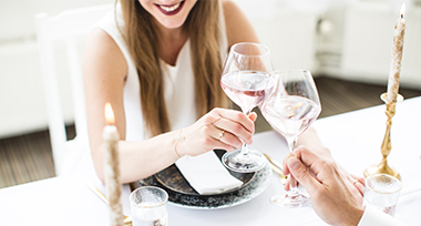 Proosten met wijnglazen tijdens een romantisch diner